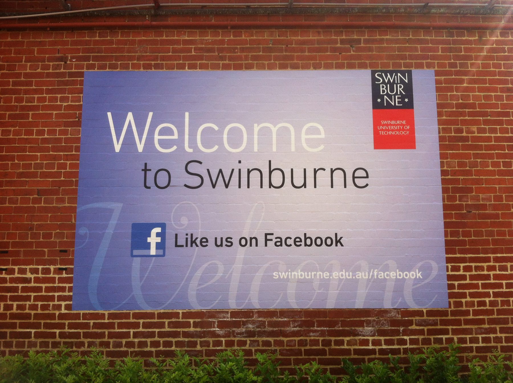 Swinburne University welcome sign mounted on brick wall